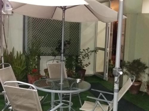 a table and chairs with an umbrella in a room at Hotel Uruguay in Montevideo
