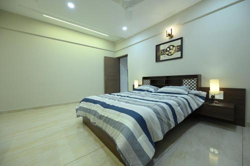 a bedroom with a large bed with blue and white sheets at The Grace Residence - Unmarried Couples Not Allowed in Manipala