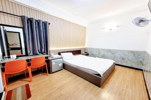 a bedroom with a bed and a desk and a mirror at Hoang Nam Hotel in Ho Chi Minh City