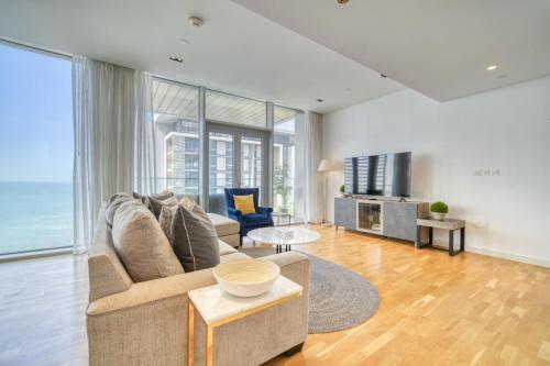 a living room with a couch and a table at Lagom Vacation Home 2 Bedroom Apartment Blue Waters in Dubai