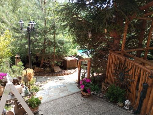 a garden with a fence and a gate and flowers at Chata u rybníka - Chrastná in Osečná