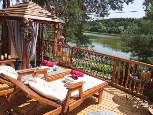 a deck with benches and a gazebo next to a river at Chata u rybníka - Chrastná in Osečná