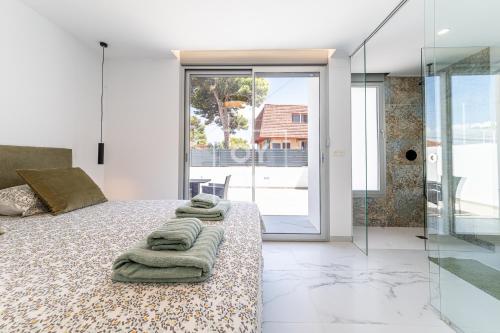 a bedroom with a bed with towels on it at Villa Coral deluxe oasis by OYOOSTAYS in Torrevieja