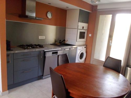 une cuisine avec une table en bois et une cuisine avec une table et des chaises dans l'établissement charmant logis avec vue sur l'Hérault pour 4 personnes à Aniane, à Aniane