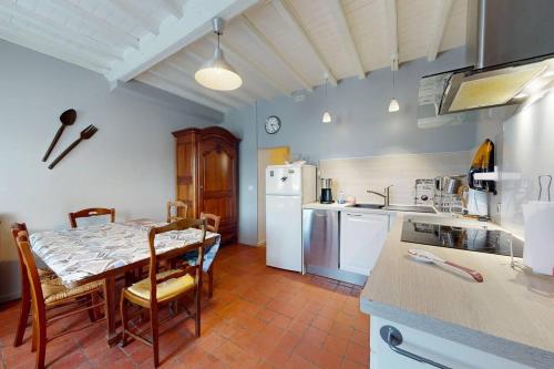 une cuisine avec une table et un réfrigérateur blanc dans l'établissement Villa Marie, à Saint-Laurent-sur-Mer