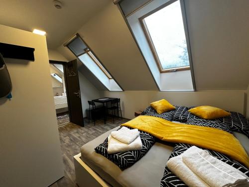 a bedroom with a bed with yellow sheets and a window at See Panzió in Fertőrákos