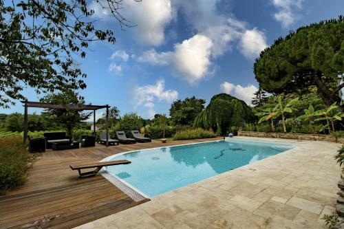 - une piscine avec une terrasse en bois à côté d'un complexe dans l'établissement L'orée des vignes, à Saint-Romain-la-Virvée