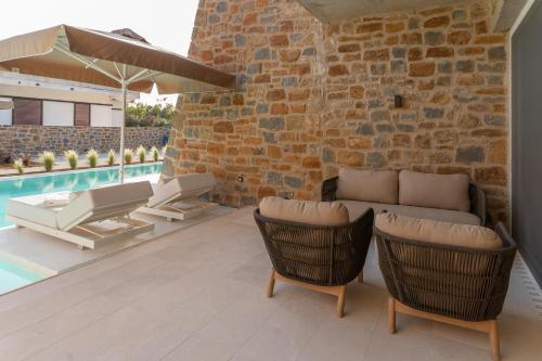 a patio with a couch and chairs and a pool at Gialova Hills 8 - Luxury Apartments with Pool in Gialova