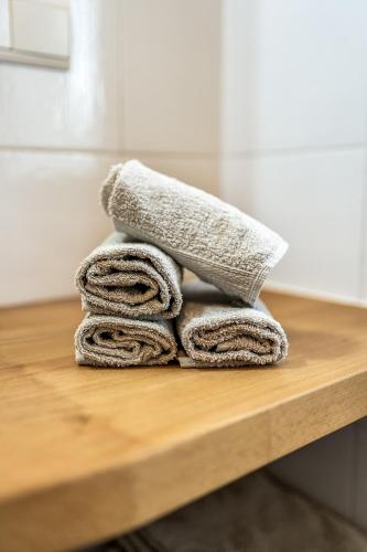 a pile of towels sitting on a wooden table at Holzerhof Lothen , Campolino in San Lorenzo di Sebato