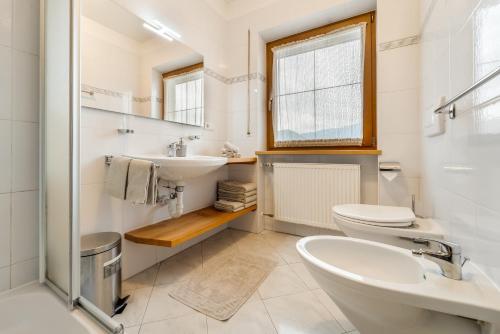 a bathroom with a sink and a toilet and a window at Holzerhof Lothen , Campolino in San Lorenzo di Sebato