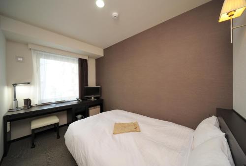 Een bed of bedden in een kamer bij Chisun Inn Kagoshima Taniyama