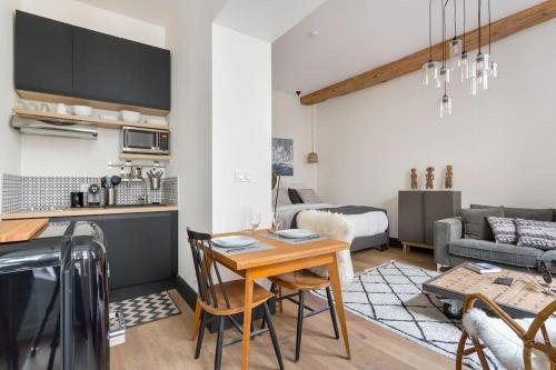 Il comprend une cuisine et un salon avec une table. dans l'établissement Mazzini, centre historique et climatisé, Lyon 1er, à Lyon