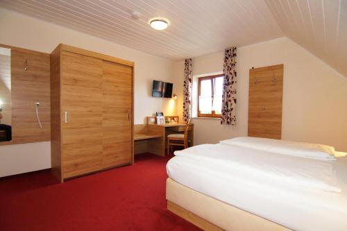 a hotel room with a bed and a desk at Gasthaus und Landhotel Wiedmann in Eresing