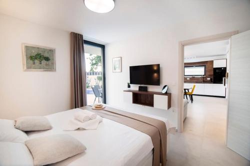 une chambre blanche avec un lit et une télévision dans l'établissement Villa Mara by IstriaLux, à Svetvinčenat