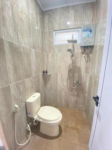 a bathroom with a toilet and a shower at Griya Dipokusuman Homestay Jogja in Timuran