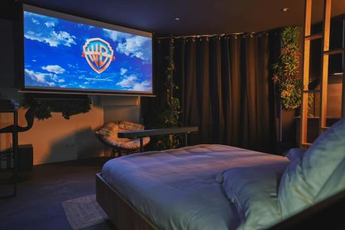 a bedroom with a large screen with a bed at Ciné jungle duplex balnéo in Roanne