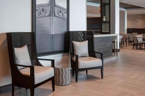 a restaurant with two chairs and a bar with tables at SpringHill Suites by Marriott Clearwater Beach in Clearwater Beach