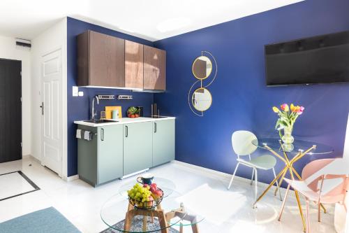 a kitchen with blue walls and a table and chairs at MOVEEN! Wynajem apartamentów we Wrocławiu! 10 minut od centrum in Wrocław