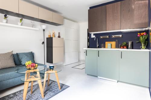 a living room with a blue couch and a table at MOVEEN! Wynajem apartamentów we Wrocławiu! 10 minut od centrum in Wrocław