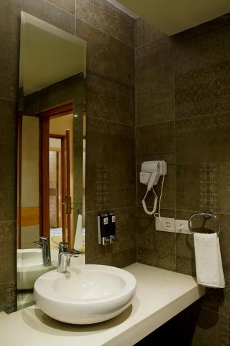 a bathroom with a sink and a mirror at Hotel Sakura Gold in Gurgaon