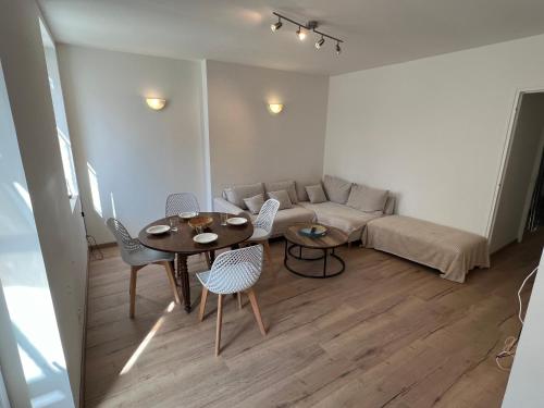 un salon avec une table, des chaises et un canapé dans l'établissement Jolie appartement 5 pers, à Saint-Fargeau