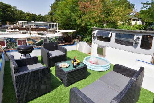 a patio with chairs and a table and a boat at Peniche refuge Seine in Vigneux-sur-Seine