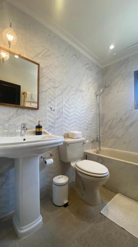 a bathroom with a toilet and a sink and a tub at T&L Apartments Germasogia in Limassol
