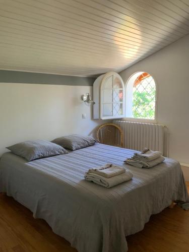 une chambre avec un grand lit avec des serviettes dessus dans l'établissement Villa l Esquiro, à Lège-Cap-Ferret