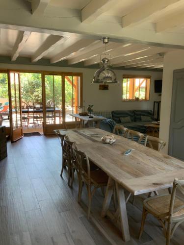 une grande table en bois dans une pièce avec des chaises dans l'établissement Villa l Esquiro, à Lège-Cap-Ferret