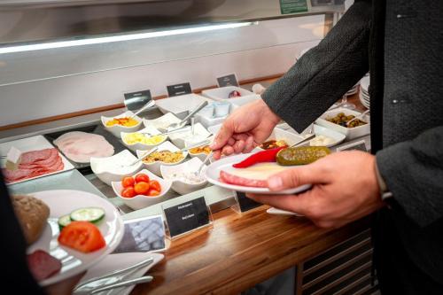 a man is preparing food in a buffet at Hotel Astor in Munich
