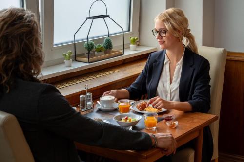 two women sitting at a table eating food at Hotel Astor in Munich
