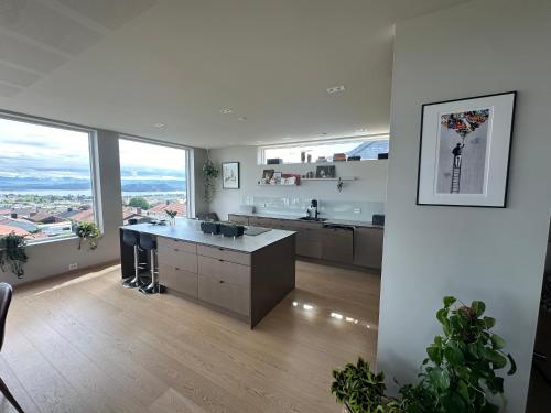 Una cocina grande con encimeras blancas y grandes ventanales. en Luxury Villa Stunning View - ONS, en Stavanger