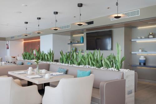 a dining room with a table and white chairs at Melia Alicante in Alicante
