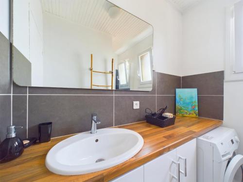 ein Badezimmer mit Waschbecken und Spiegel in der Unterkunft À 300m de la plage, maison pour 5 in Brétignolles-sur-Mer