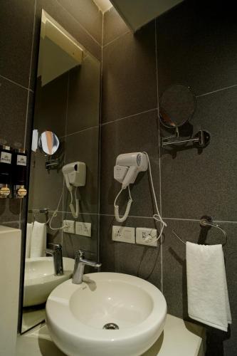 a bathroom with a sink and a mirror at Hotel Sakura Gold in Gurgaon