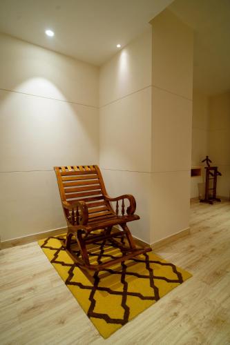 a wooden bench sitting on a rug in a room at Hotel Sakura Gold in Gurgaon