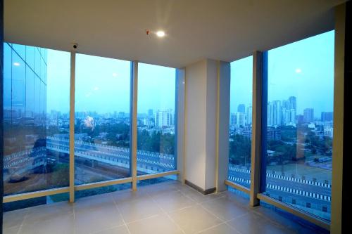 a room with large windows with a view of a city at Hotel Sakura Gold in Gurgaon