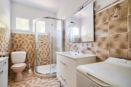 een badkamer met een douche, een toilet en een wastafel bij À moins de 2km de la plage, maison pour 6 in Andernos-les-Bains