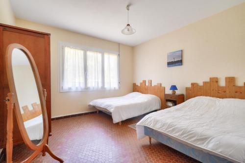 een slaapkamer met twee bedden en een spiegel bij À moins de 2km de la plage, maison pour 6 in Andernos-les-Bains