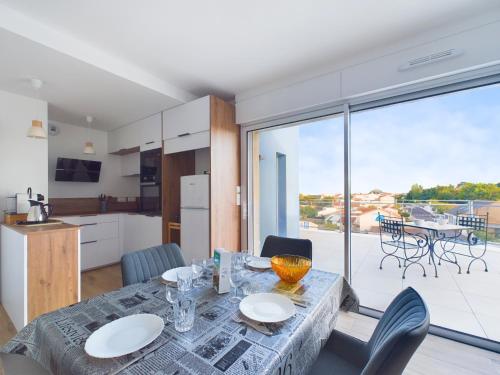une cuisine et une salle à manger avec une table et des chaises dans l'établissement Appartement pour 6 proche plage et port, à Saint-Gilles-Croix-de-Vie