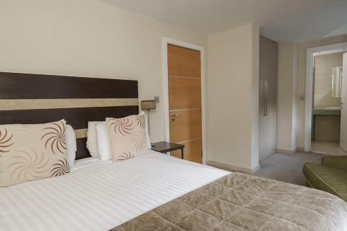 a bedroom with a large bed and a couch at Fanhams Hall, Exclusive Collection in Ware