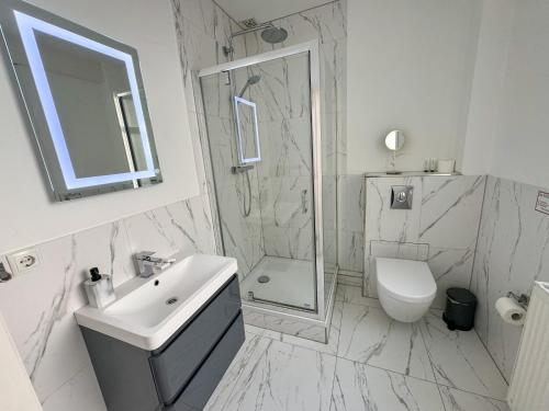 Un baño con lavabo, ducha e inodoro. en Yourbnb Suites Haarlemmerstraat, en Ámsterdam