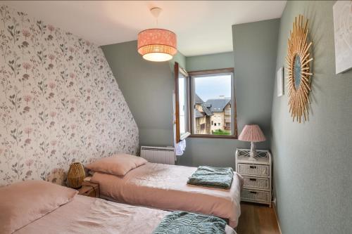 une chambre avec deux lits et une fenêtre dans l'établissement L'Aquilon - A moins d1 Km de la plage, à Cabourg