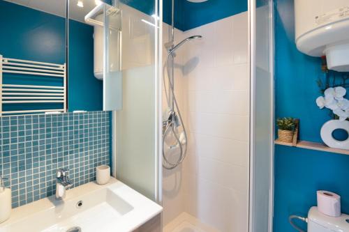 une salle de bain avec douche et lavabo dans l'établissement L'Aquilon - A moins d1 Km de la plage, à Cabourg