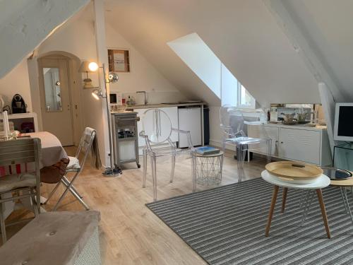 ein Wohnzimmer mit Tisch und Küche in der Unterkunft Appartement à 2 pas de la plage in Cabourg