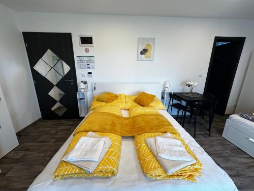 a bedroom with a bed with a yellow comforter at See Panzió in Fertőrákos