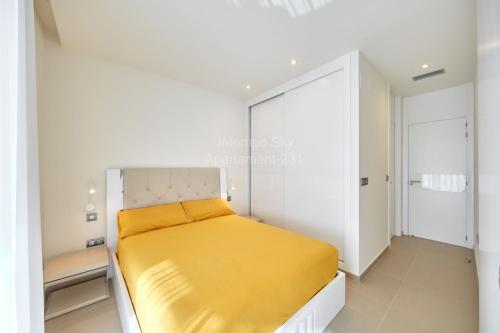 a bedroom with a yellow bed in a white room at INTEMPO SKY Apartament-231 in Benidorm