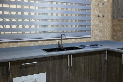 a kitchen with a sink and a window at Atom Height Apartments in Tema