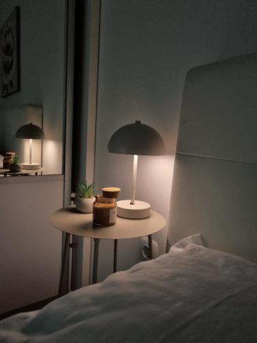 a table with a lamp on it next to a bed at Sunset in Teslić