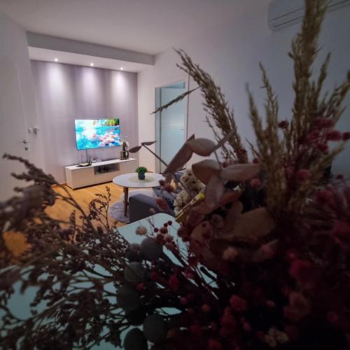 a person sitting in a living room with a tv at Sunset in Teslić